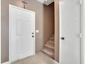 Inviting entryway with a white door and neutral-toned walls leading to carpeted stairs at 1457 Summer Glow Ave, Henderson, NV 89012
