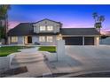 Exterior view of a two-story home with a three-car garage, landscaped front yard, and inviting entryway at 1912 Calanda Ct, Las Vegas, NV 89102