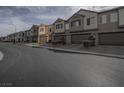 Street view of modern townhomes, each featuring two-car garages and neat landscaping at 3795 Canis Minor Ln # 5102, Henderson, NV 89052