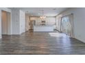 Open-concept living space featuring wood-look flooring, a kitchen with white cabinets, and stainless steel appliances at 3795 Canis Minor Ln # 5102, Henderson, NV 89052