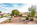 Inviting single-story home boasts desert landscaping, mature trees, and a long driveway, creating excellent curb appeal at 4343 Sharpshooter Ln, North Las Vegas, NV 89031