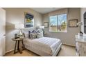 Neutral bedroom with patterned bedding, decorative pillows, side tables with lamps, and a window with natural light at 4420 Stardusk Falls Ave, North Las Vegas, NV 89084