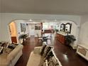 Bright, open concept living room featuring hardwood floors, modern furnishings, and a view of the dining room at 4861 Pahrump Valley Blvd, Pahrump, NV 89048