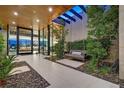 Covered front porch featuring a modern bench swing, landscaping, and grand entrance at 49 Crested Cloud Way, Las Vegas, NV 89135
