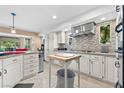 Modern kitchen features white cabinetry, stainless steel appliances, tiled backsplash and convenient central island with butcher block at 5205 Sandy Cactus Ln, Las Vegas, NV 89149