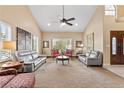 Bright and airy living room featuring neutral walls, carpet floors, and large windows with views of the greenery outside at 5205 Sandy Cactus Ln, Las Vegas, NV 89149