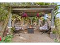 Cozy patio area with pergola, hanging flower baskets and comfortable seating at 5205 Sandy Cactus Ln, Las Vegas, NV 89149