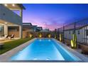 Stunning backyard featuring a rectangular pool with a turf area and modern outdoor furniture for elegant outdoor living at 532 Crown Mesa Ave, Las Vegas, NV 89138