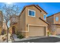 Two-story tan home with a two car garage with minimal landscaping and arched entry way at 6217 Red Jamboree Ct, Las Vegas, NV 89130