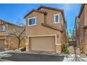 Two-story tan home featuring a two-car garage and minimal landscaping on a sunny day at 6217 Red Jamboree Ct, Las Vegas, NV 89130