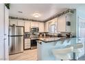 Well-lit kitchen with stainless steel appliances, granite countertops, and a breakfast bar at 6883 Tamarus St # 203, Las Vegas, NV 89119