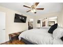Bright bedroom boasts a mirrored closet, ceiling fan, and wood floors at 7950 W Flamingo Rd # 2142, Las Vegas, NV 89147