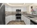 Well-lit kitchen featuring stainless steel appliances, granite countertops, and white cabinets at 7950 W Flamingo Rd # 2142, Las Vegas, NV 89147