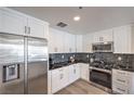 Well-equipped kitchen with stainless steel appliances, including a refrigerator and gas range with black backsplash at 8777 W Maule Ave # 3090, Las Vegas, NV 89148