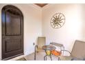 Cozy patio with a decorative sunburst wall hanging, chairs, and a small table at 10 Via Visione # 103, Henderson, NV 89011