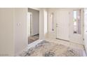 Bright entryway with neutral tile flooring, a decorative front door, and an adjacent hallway at 10057 Bundella Dr, Las Vegas, NV 89134