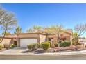 Charming single-story home featuring a terra cotta roof, a two-car garage, and desert landscaping at 10057 Bundella Dr, Las Vegas, NV 89134