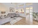 Well-lit living room with wood floors, modern furnishings, and a view into an adjacent sitting room at 10057 Bundella Dr, Las Vegas, NV 89134