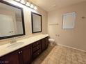 Bathroom with double sink vanity, tile floor, and toilet at 11763 Village Arbor St, Las Vegas, NV 89183