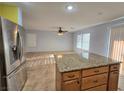 Open concept kitchen featuring tile floors, a center island, granite countertops, and stainless steel appliances at 11763 Village Arbor St, Las Vegas, NV 89183
