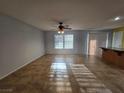 Spacious living room featuring tile floors, ceiling fan, and natural light from windows with privacy blinds at 11763 Village Arbor St, Las Vegas, NV 89183