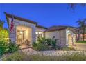 Inviting front porch with cozy seating, lush landscaping, and a charming American flag at 1900 Vero Dr, Las Vegas, NV 89134