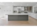 Modern kitchen featuring stainless steel appliances, sleek white cabinets, a stylish island, and bright, open space at 2894 Matese Dr, Henderson, NV 89052