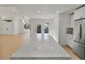 Open-concept kitchen featuring a large island with marble countertops, modern appliances, and access to outdoor spaces at 2894 Matese Dr, Henderson, NV 89052