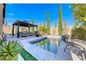 Relaxing backyard featuring a pool, spa and covered seating, perfect for outdoor entertaining at 312 Castellari Dr, Las Vegas, NV 89138