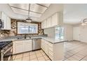 Bright kitchen features white cabinets, stainless steel appliances, granite counters, and view to the backyard pool area at 3577 Wayne Cir, Las Vegas, NV 89121