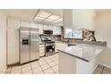 Updated kitchen with stainless steel appliances, granite countertops, modern cabinets, and tile flooring, offering both style and functionality at 3577 Wayne Cir, Las Vegas, NV 89121