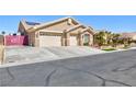 Tan single-story home with a three-car garage and paved driveway provides ample parking at 3662 Riley Ann Ave, Las Vegas, NV 89139