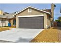 Detached two-car garage featuring a dark gray door, concrete driveway, and tasteful desert landscaping in a residential neighborhood at 3914 Steinbeck Dr, Las Vegas, NV 89115