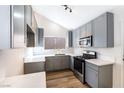 Modern kitchen with gray cabinets, quartz countertops, stainless steel appliances, and wood-look flooring at 3914 Steinbeck Dr, Las Vegas, NV 89115