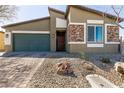 Single-story home with a two car garage, desert landscaping and stone facade at 4227 Diya Ave, North Las Vegas, NV 89084