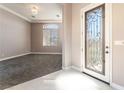 Bright foyer featuring decorative glass door, elegant tile flooring, and an open view to a carpeted living space at 5027 Crown Cypress St, Las Vegas, NV 89149