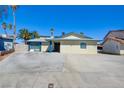 Charming single-story home featuring a large driveway, desert landscaping and clear blue skies at 6710 Redwood Cir, Las Vegas, NV 89103