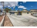 Single-story home featuring a large driveway, desert landscaping and blue trim at 6710 Redwood Cir, Las Vegas, NV 89103