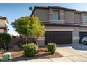 Charming home exterior with a two-car garage, desert landscaping, and a paved driveway at 717 W Colton Ave, North Las Vegas, NV 89032
