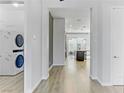 Hallway view of the open-concept living area, kitchen, and laundry room with a stackable washer and dryer at 783 Hibiscuss Blossom St, Henderson, NV 89011