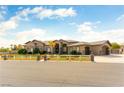 Beautiful single-story home with desert landscaping and a white fence at 8925 Silent Brook Ct, Las Vegas, NV 89149