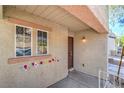 Close-up of the front porch adorned with colorful floral decorations and a classic dark-stained front door at 9117 Careful Canvas Ave, Las Vegas, NV 89149