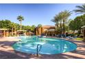 Beautiful community pool with lounge chairs and palm trees on a sunny day at 950 Seven Hills Dr # 814, Henderson, NV 89052