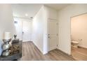Bright entryway featuring wood-look floors, white walls, and a view into a half bathroom at 1027 Gentle Swan St # 689, Henderson, NV 89011