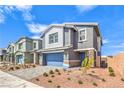 Attractive two-story home with paver driveway, stone accents, and desert landscaping in a residential neighborhood at 1027 Gentle Swan St # 689, Henderson, NV 89011