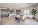 Bright, open-concept kitchen with gray cabinetry, stainless steel appliances, and center island with seating at 1027 Gentle Swan St # 689, Henderson, NV 89011
