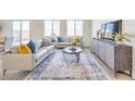 Bright living room with modern furnishings, neutral walls, ample natural light, and wood-look floors at 1027 Gentle Swan St # 689, Henderson, NV 89011