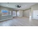 Spacious open-concept living room with high ceilings, ceiling fan, and wood-look floors at 1131 Lupin St, Pahrump, NV 89048