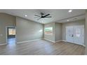 Bright living room with ceiling fan, and wood-look floors with double doors at 1131 Lupin St, Pahrump, NV 89048