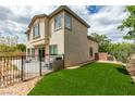 A fully fenced yard features artificial grass, a patio and desert landscaping for easy maintenance and enjoyment at 11769 Via Vera Cruz Ct, Las Vegas, NV 89138